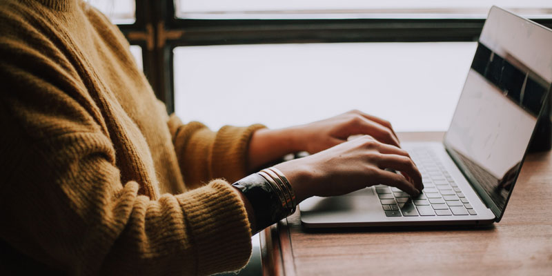 woman typing on laptop keyboard